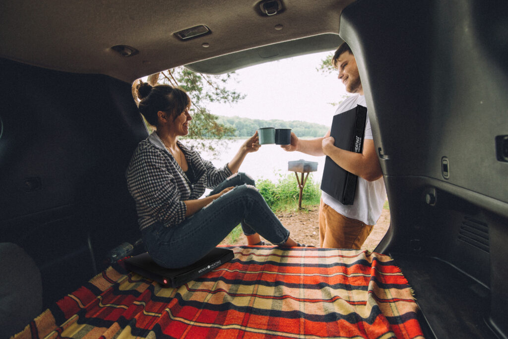 couple resting outside. car travel concept. sitting in trunk